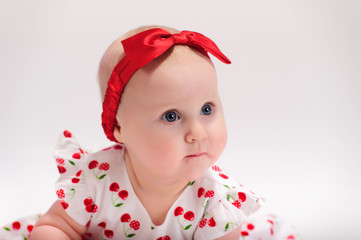 Little girl in white with a red dress with a bow on her head