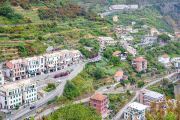 Fototapeta na wymiar View to city buildings and mountains in a foggy day. Riomaggiore, Italy