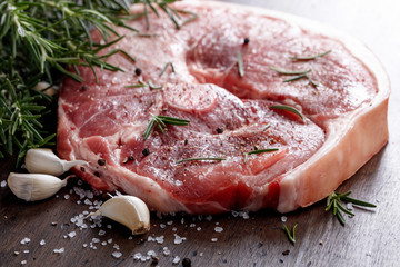 Raw pork with rosemary , salt and pepper.