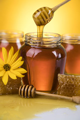 Honey jar, flower with dipper and flowing honey