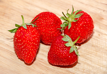 Red strawberries fruits, rustic wood background, close up