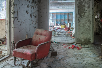 Red armchair at abandoned room in Chernobyl nuclear disaster area.