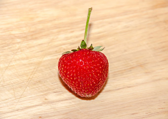 Red strawberry fruit, rustic wood background, close up
