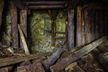 Abandoned old chromite mine shaft tunnel with wooden timbering