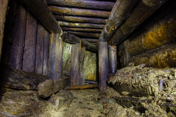 Fototapeta na wymiar Underground abandoned old mine shaft iron copper gold ore tunnel gallery with wooden stands timbering