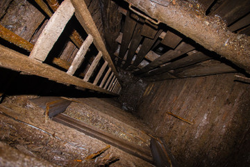 Deep underground wooden mine shaft with stairs