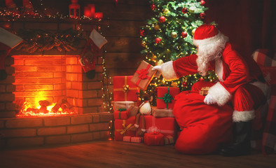 Merry Christmas! santa claus near the fireplace and tree with gifts