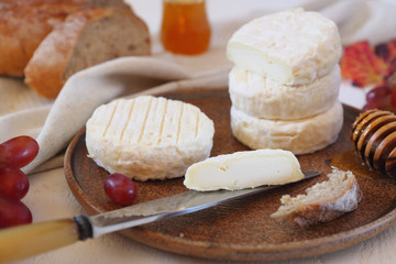 French goat cheese, honey, red grape and bread. Toned image, focus selective