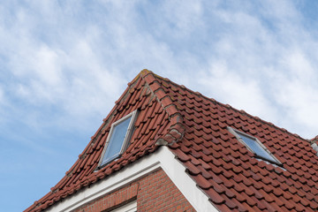 Fenster eines Hauses mit roten Dachziegeln und Backsteinen
