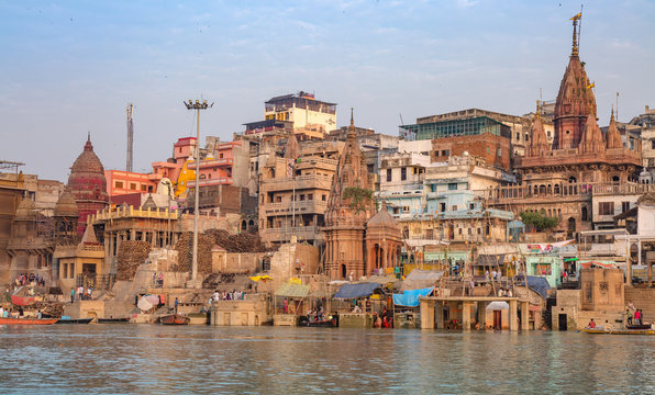 Varanasi city with old architectural buildings and ancient temples along the Ganges river ghat as viewed from a boat.