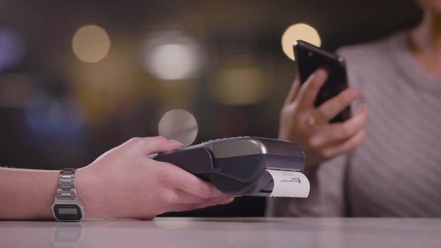 Close up of woman paying in a cafe.