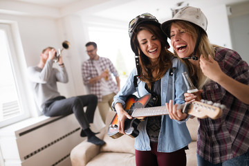 Happy young friends having fun and partying to music