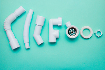 White plastic fittings for plumbing on a blue background
