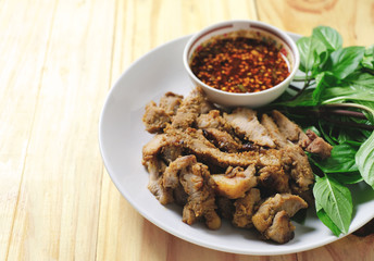 roasted pork thai style with spicy sauce on wood table