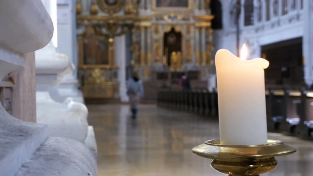 MUNICH, GERMANY, SEPTEMBER 15, 2017: The candle burns in the church of St. Michael. Munich, Germany. Architecture Christian Orthodox Church Interior. Religious People in Orthodox temple.