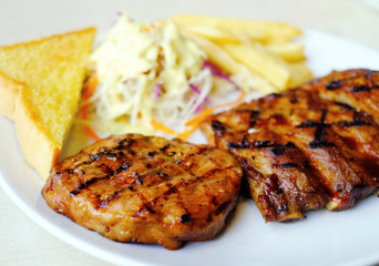 closeup barbecue pork rib serve with salad, frenchfries and butter bread