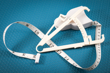 Healthy lifestyle, diet and fitness concept with measuring tape and calipers used in measuring body...