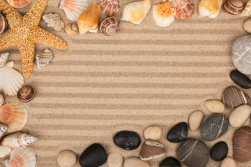Frame made of sea shells, stars and stones lying on striped sand.