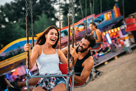 Young couple enjoying on the swings