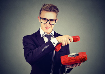 Annoyed sly young business man hanging up telephone