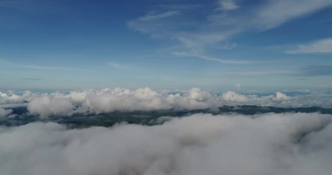 Aerial View. Flying over the beautiful mountain in clouds.