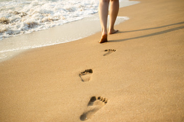 Footprint on the beach with sea wave background.