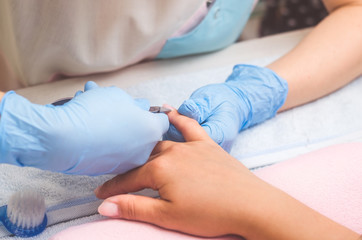 The master prepares the nails for manicure