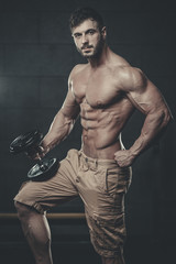 Naklejka na ściany i meble Attractive model young man training in gym
