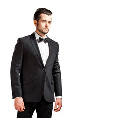 portrait of confident handsome man in black suit with bowtie