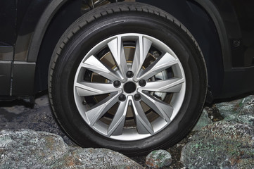 The front part of the black car, the wheel. Side view