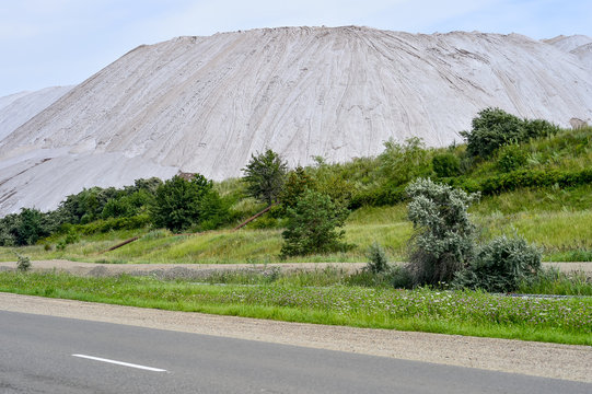 View Of The Salt Mine And An Artificial Mound With Green Grass In The Foreground