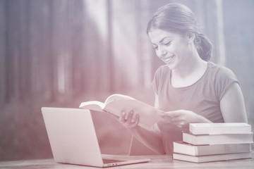 Young woman using laptop computer and smart phone. Beautiful student girl working on laptop