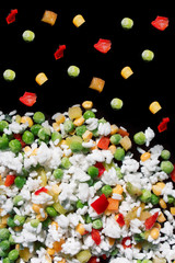 Sliced frozen vegetables for a good diet, on a black background, vertical frame