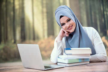 Pretty woman wearing hijab in front of laptop