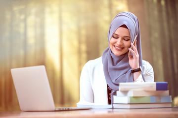 Pretty woman wearing hijab in front of laptop