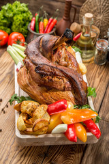 Roasted sliced pork ham and roast vegetables on dark rustic background