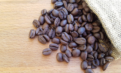 Coffee beans in a bag on wooden background