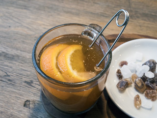 Tea in a transparent cup with orange slices, white and brown sugar refined sugar