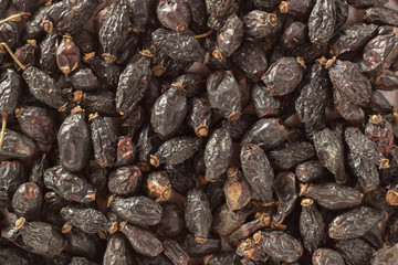 Background of a large quantity of dried rosehip berries and spoon