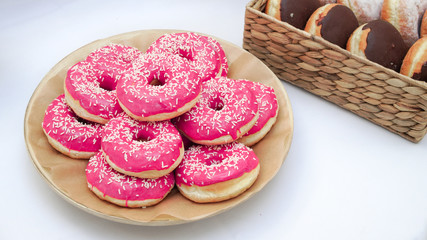 Pink donuts with icing and sprinkles, on white background