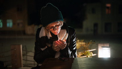 Young stylish woman in hat smoking at the street