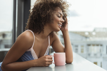 Cheerful girl drinking cup of liquid