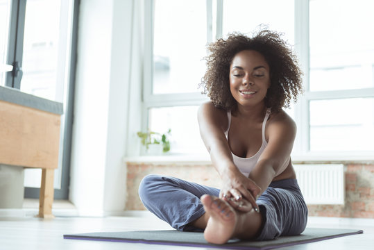 Smiling female doing pilates at home