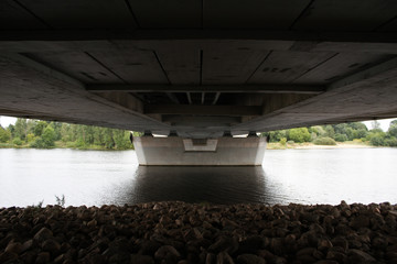 Under bridge view with river floating under it.