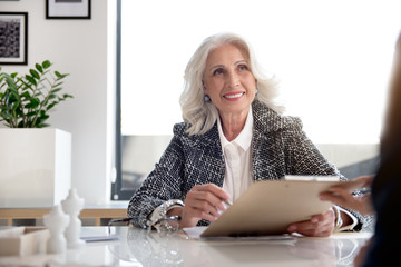 Joyful gorgeous old woman is holding documents