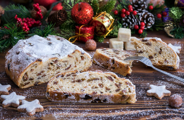 Frisch geschnittener Christstollen zur Adventszeit auf Holzuntergrund