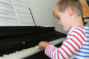 Jeune enfant qui apprend à jouer au piano