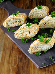 Snack rolls made of crepes and a filling on a wooden background