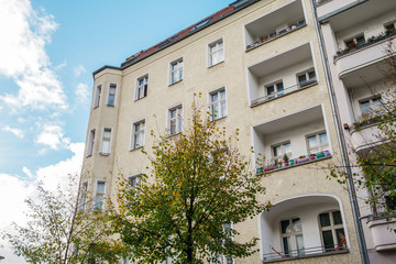 Fototapeta na wymiar yellow corner building with green tree