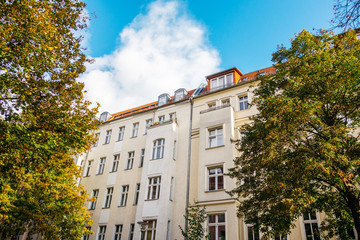 Fototapeta premium residential real estate houses, framed by trees with big clouds